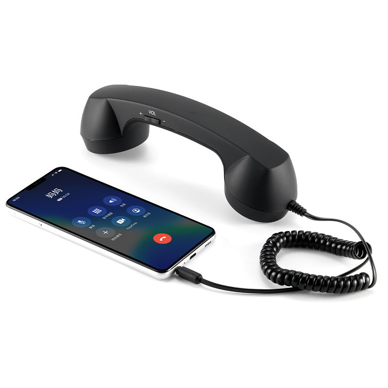 Black handset plugged into a smartphone during a call