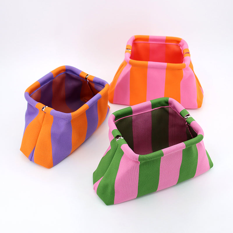 Three colourways of the cloud clutch: purple, pink-orange and green stripes